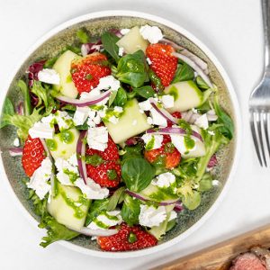 Jordbærsalat med honning melon, rødløg og feta. Hertil en mynte-hyldeblomst og limedressing